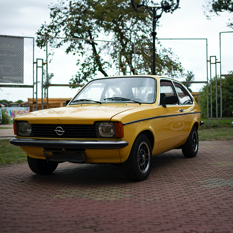 A yellow car parked on the side of a road.