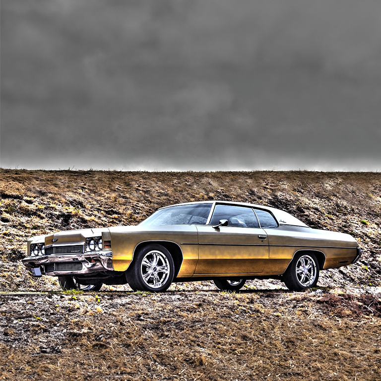 A car parked on top of a hill near some dirt.